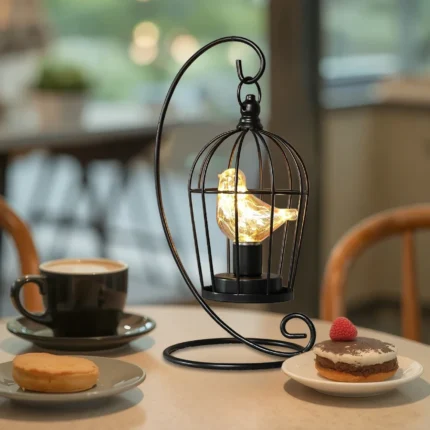 Black metal birdcage-style battery table lamp with warm yellow light