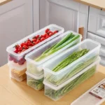 Four clear rectangular reusable plastic food storage containers arranged for refrigerator organization