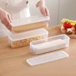 Four clear rectangular reusable plastic food storage containers arranged for refrigerator organization